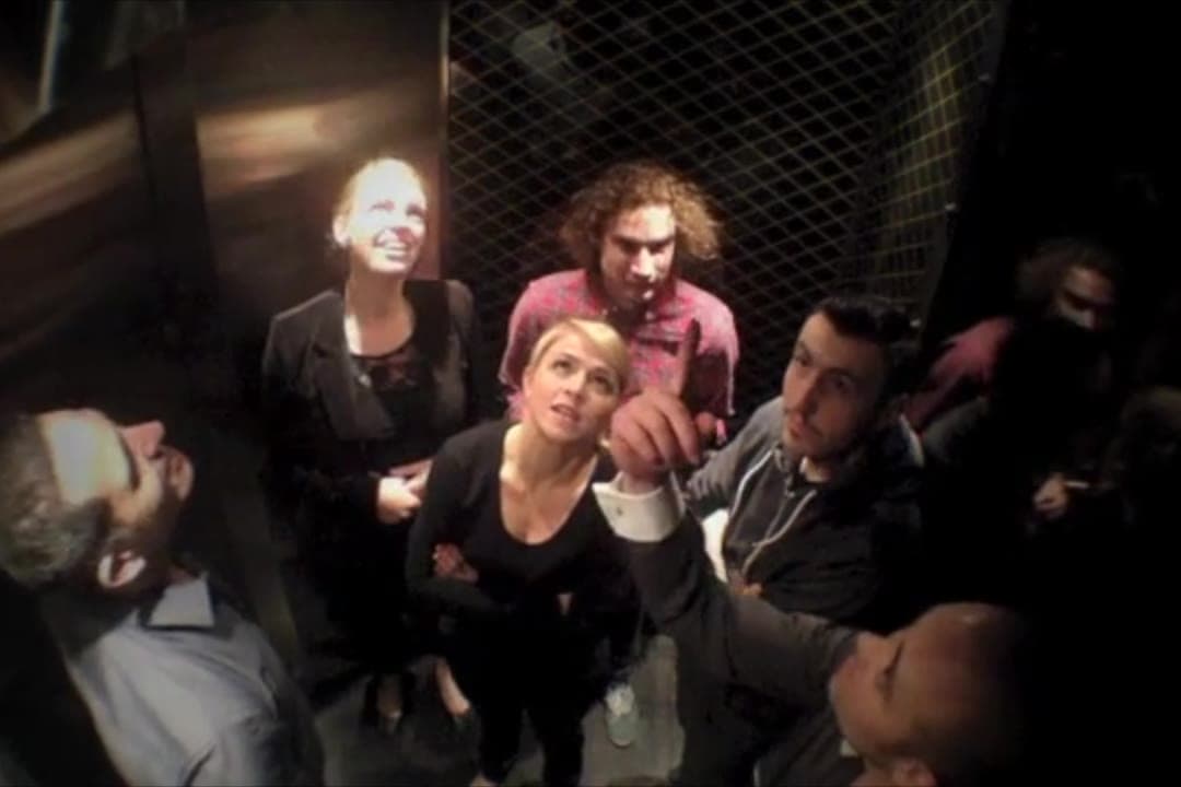 Guests in a QT Sydney lift look up as the music changes