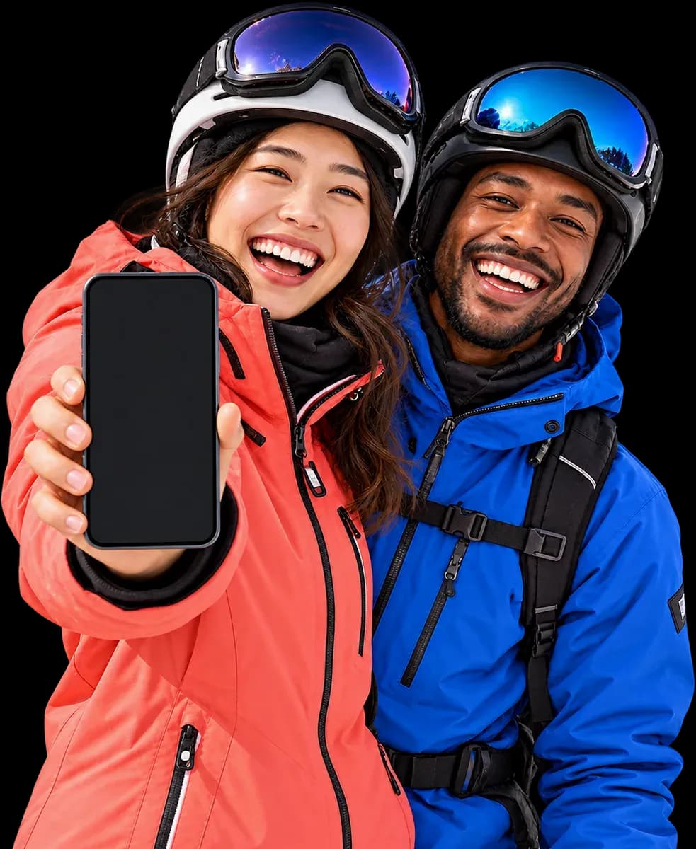Two skiers in helmets and goggles, one holding a phone